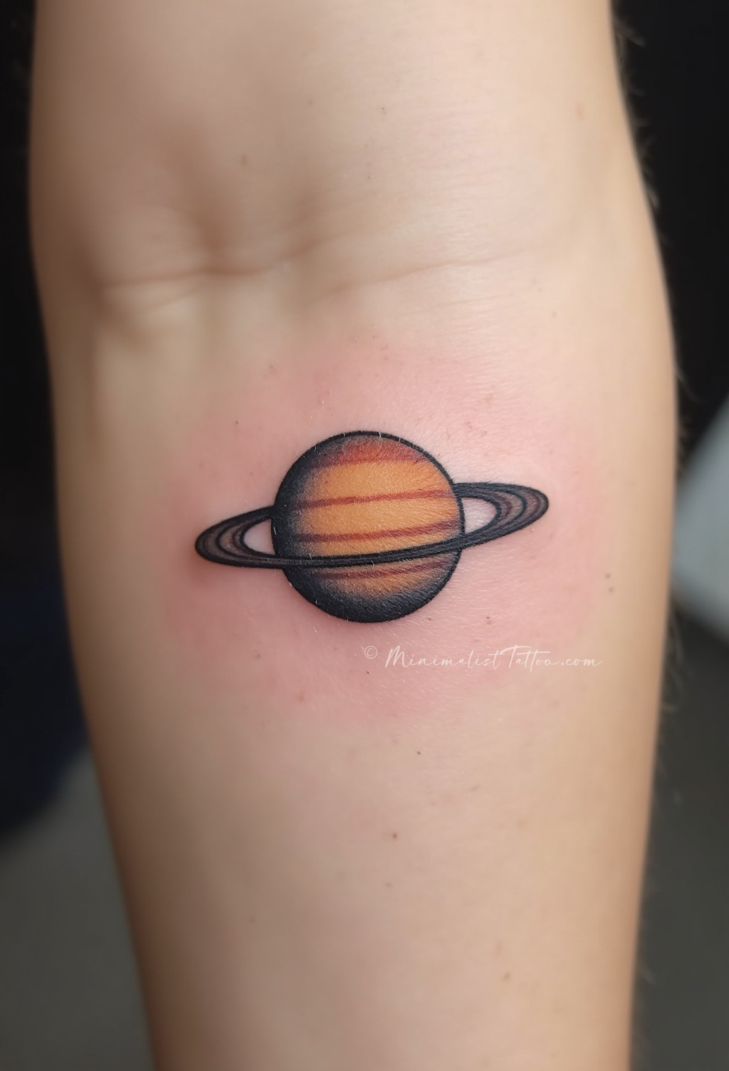 Minimalist Saturn finger tattoo