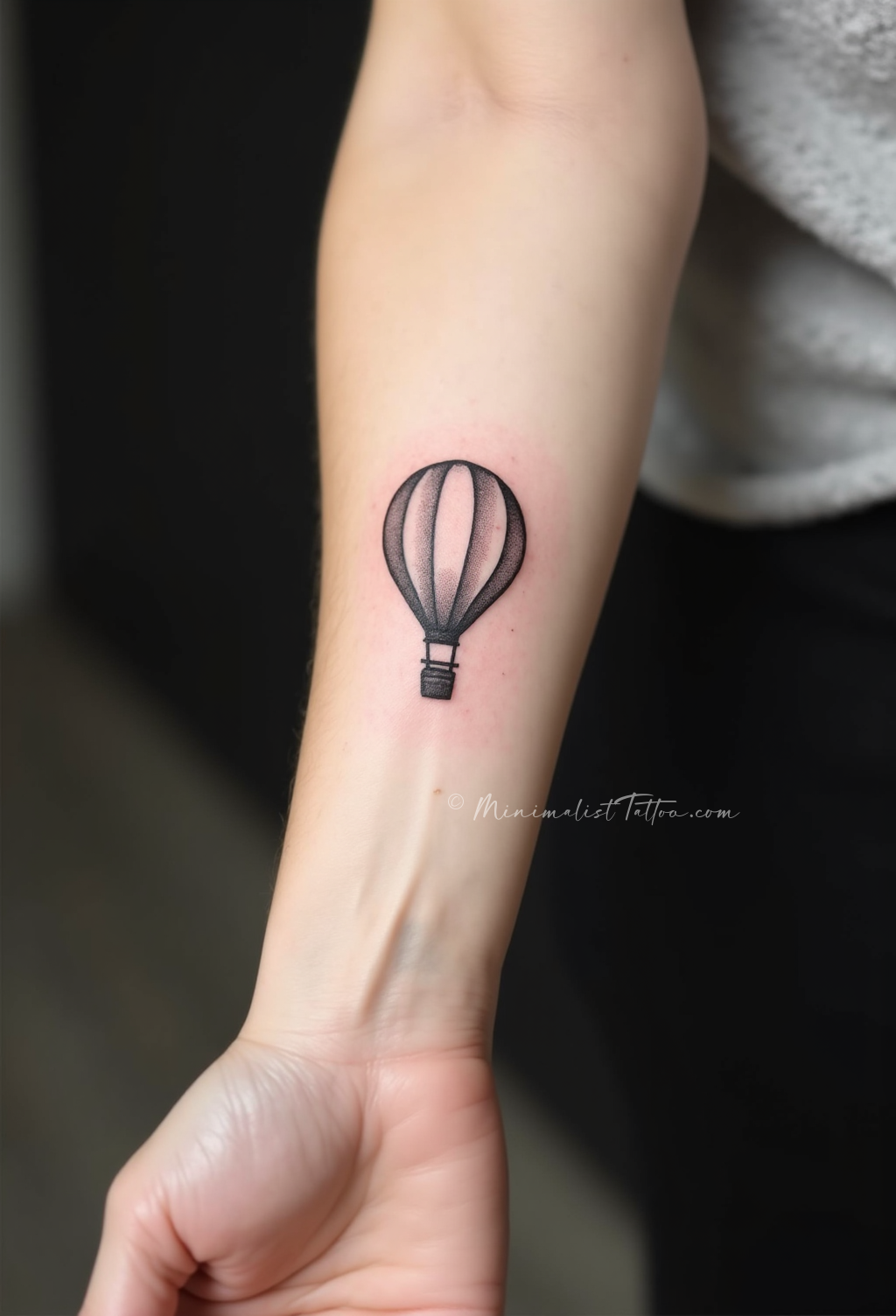Minimalist hot air balloon forearm tattoo