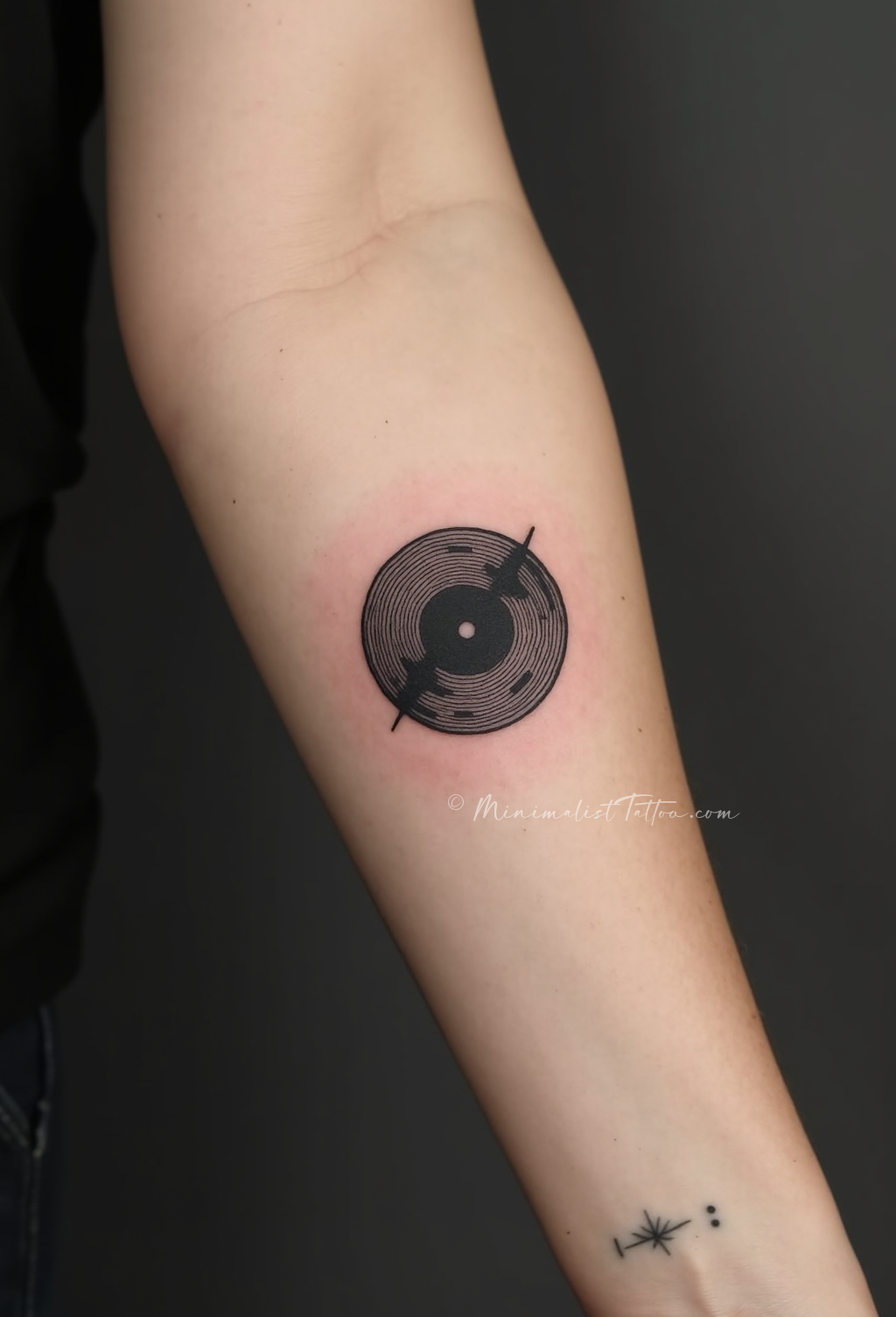Minimalist vinyl record inner arm tattoo